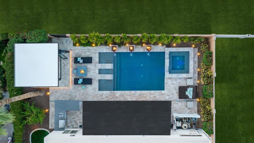 Aerial view of a modern backyard with a swimming pool, lounge area, and landscaped greenery.