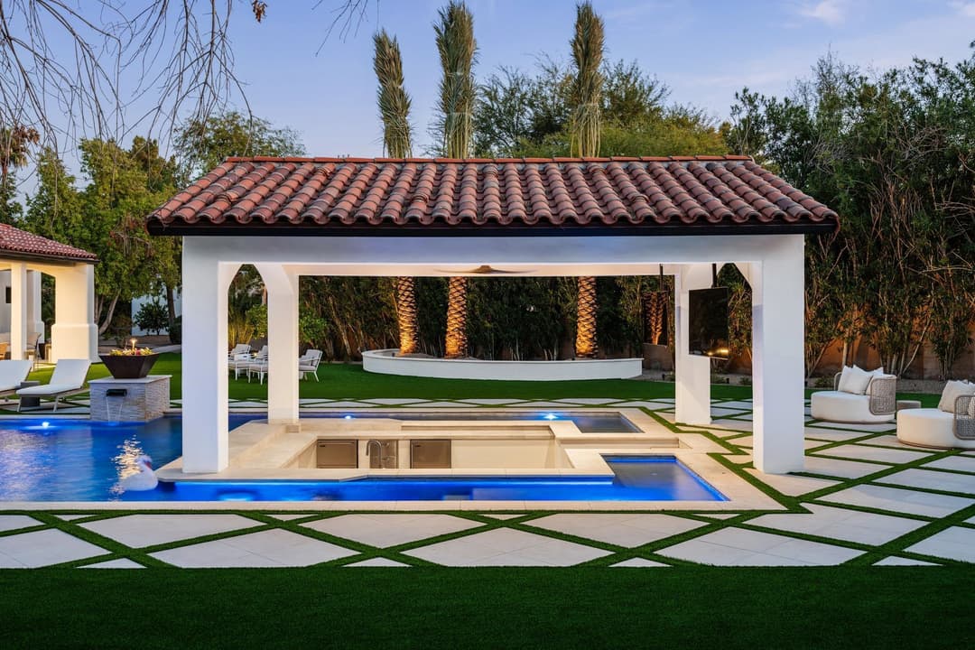 Luxury backyard oasis featuring a pool, spa, and elegant outdoor living spaces.