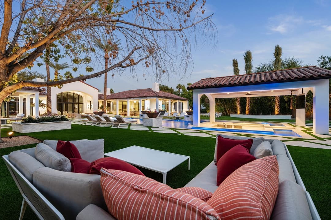 Luxury outdoor lounge area with pool, modern furniture, and vibrant landscaping.