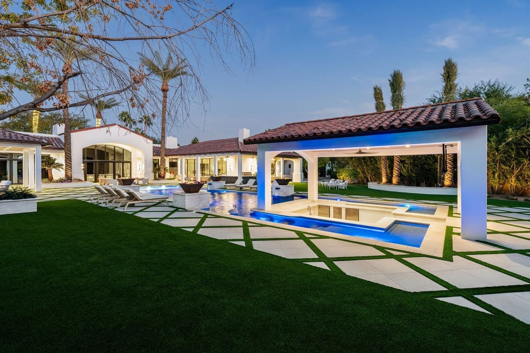 Luxury villa with pool and landscaped garden, featuring modern architecture and outdoor lounge area.